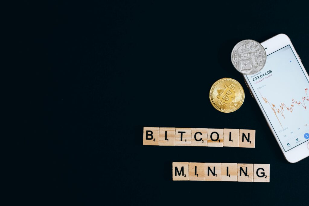 A Smartphone and Bitcoin on a Black Surface