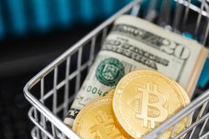 Close-up of bitcoin coins and US dollar bills in a small shopping cart, symbolizing online shopping and cryptocurrency investment.