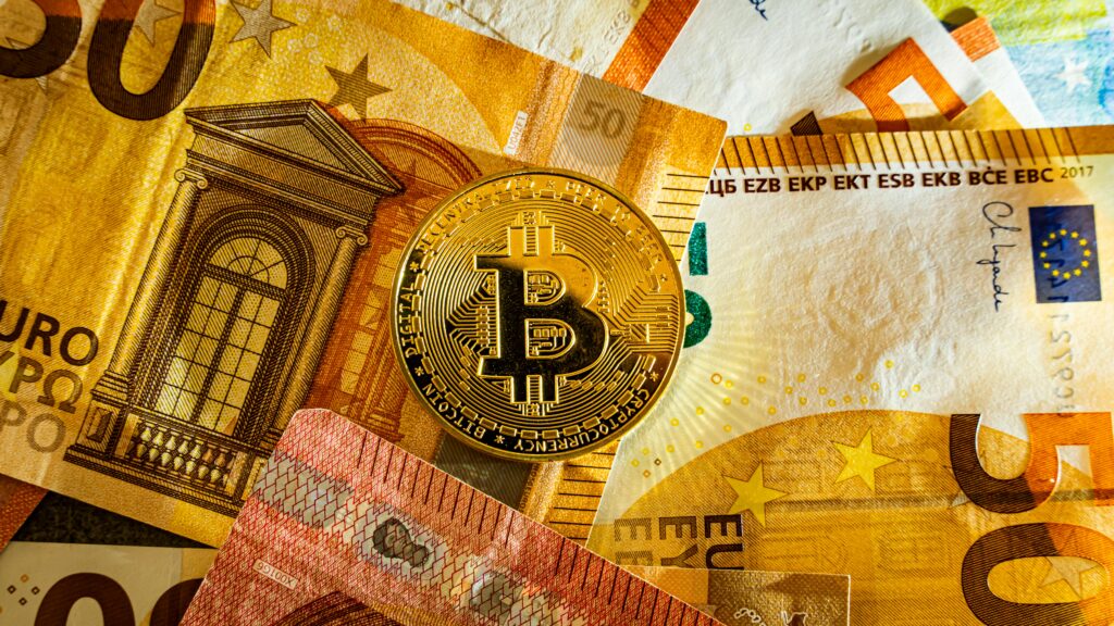 Golden Bitcoin coin placed on euro banknotes symbolizing digital currency and modern finance.